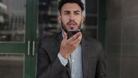 Focused-man-with-bristle-talking-on-smartphone-outdoor